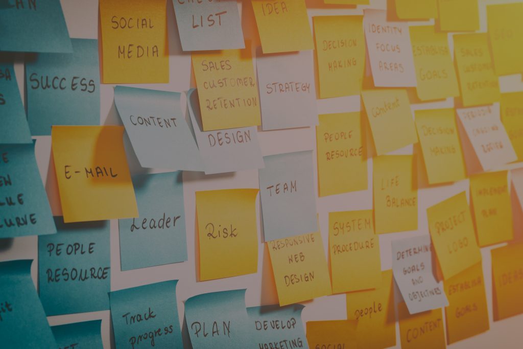 White wall with yellow and blue sticky notes on with important words on